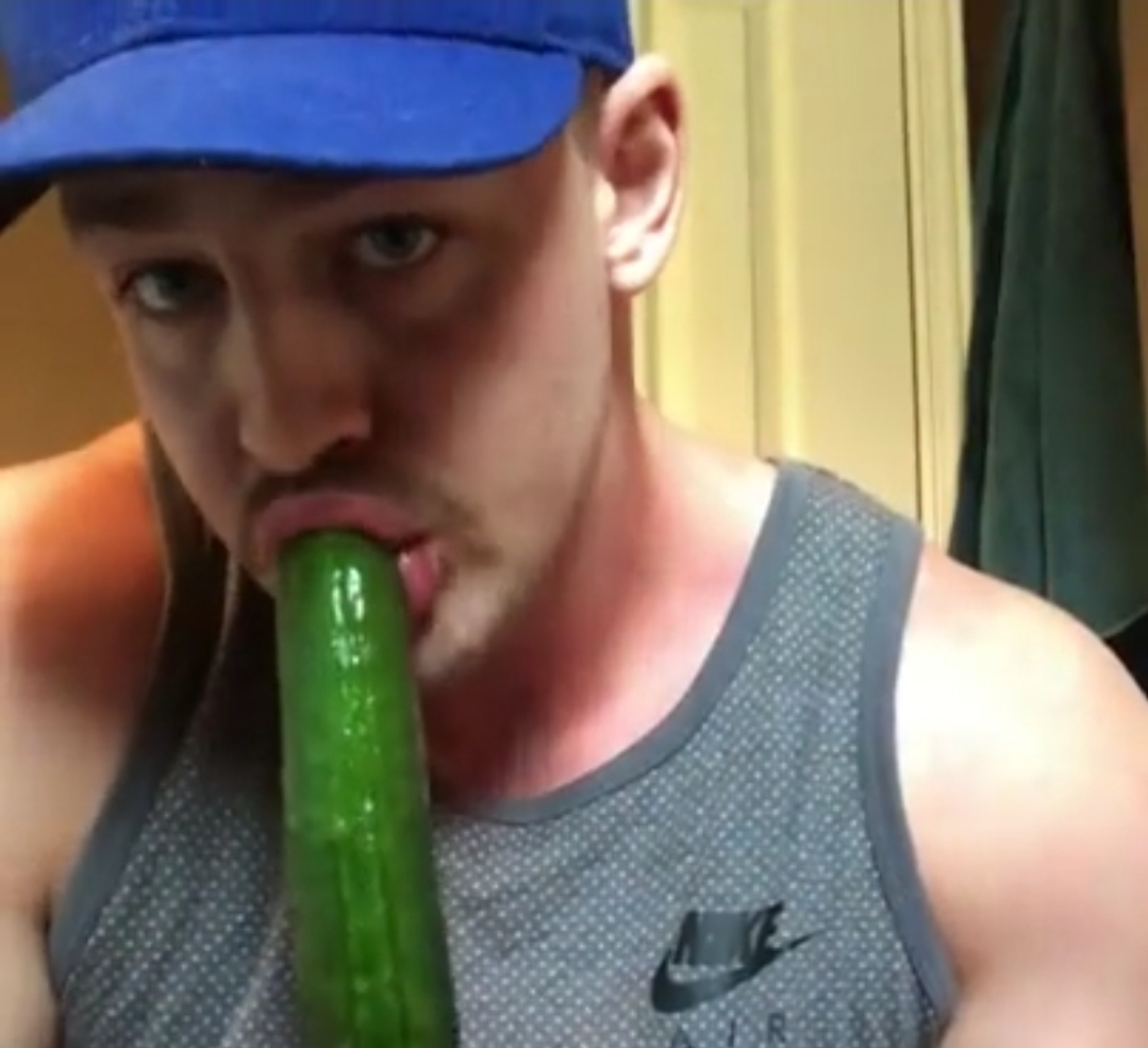 Guy having fun with a big cucumber