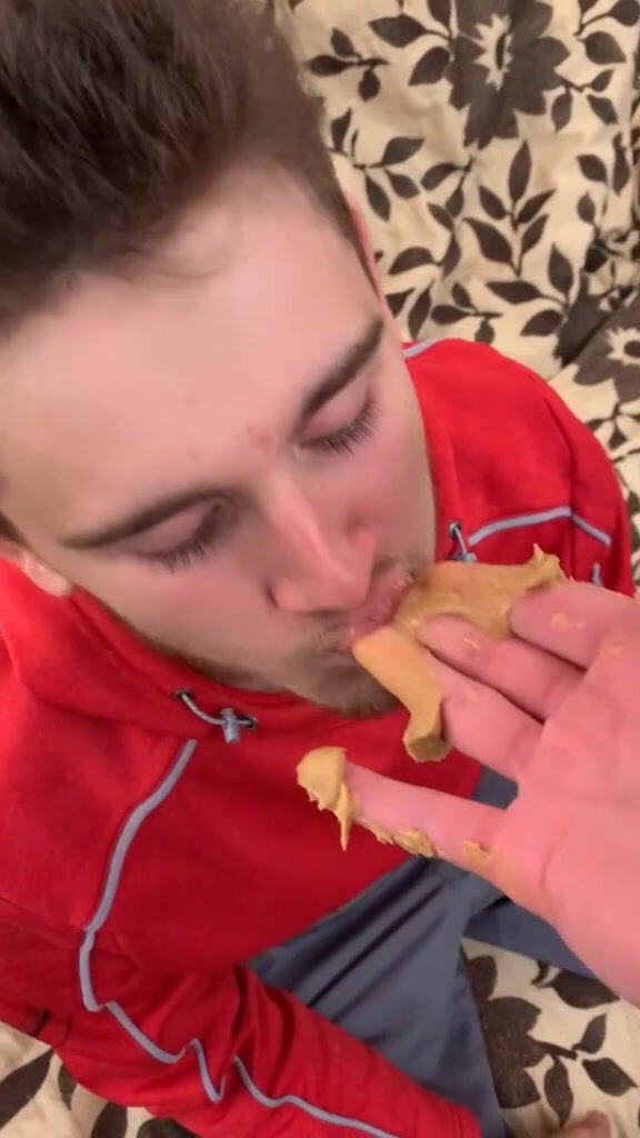 Eating peanut butter from his friend's fingers