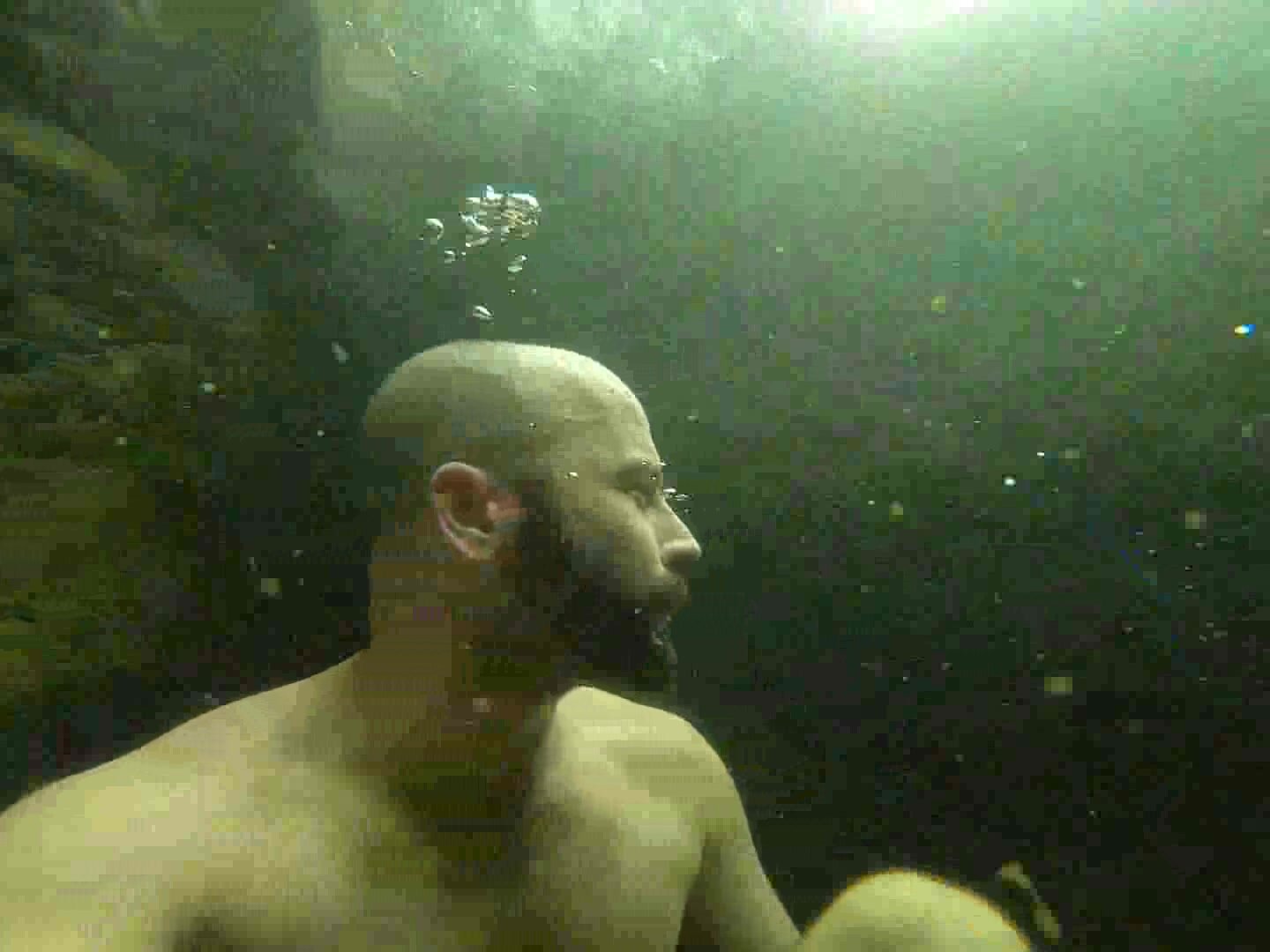 Bald bearded guy barefaced underwater