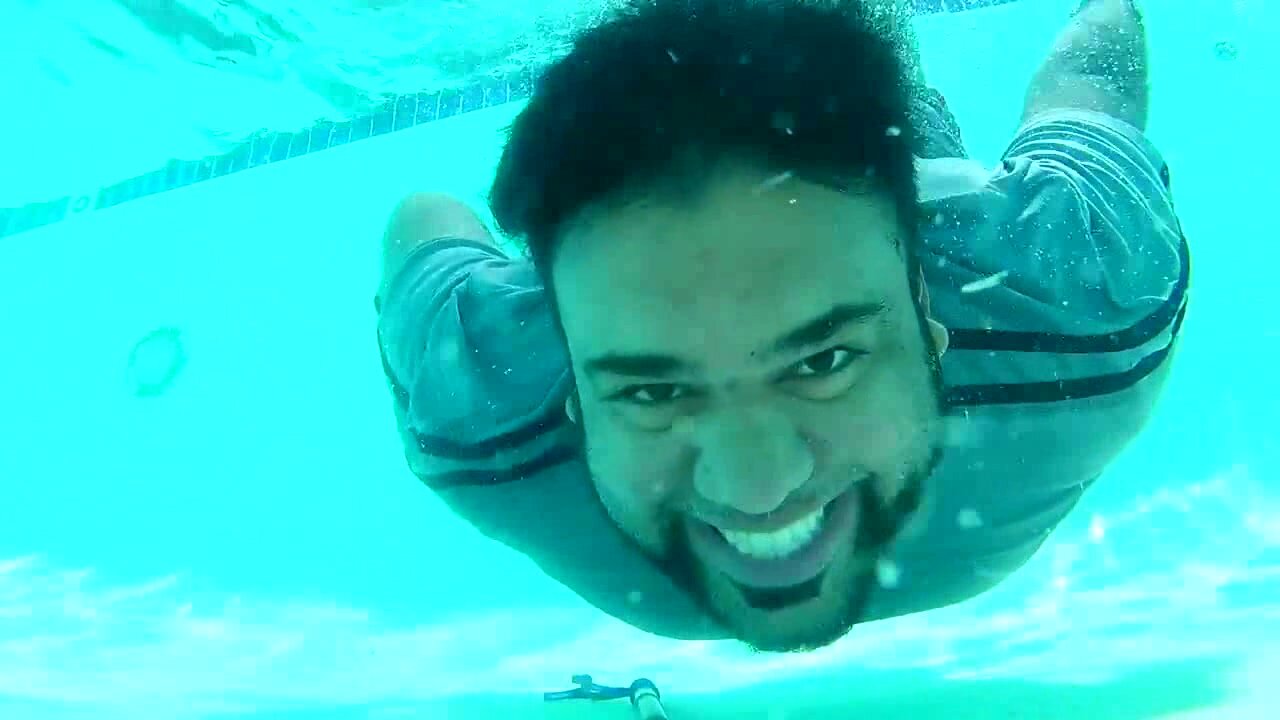 Barefaced beefy guy colthed underwater