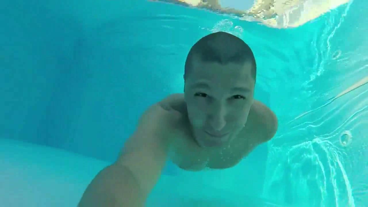 Short haired guy swims barefaced underwater