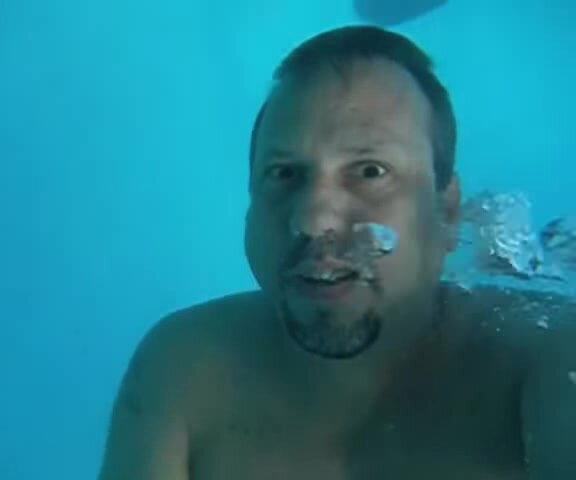 Beefy guy with goatee barefaced underwater