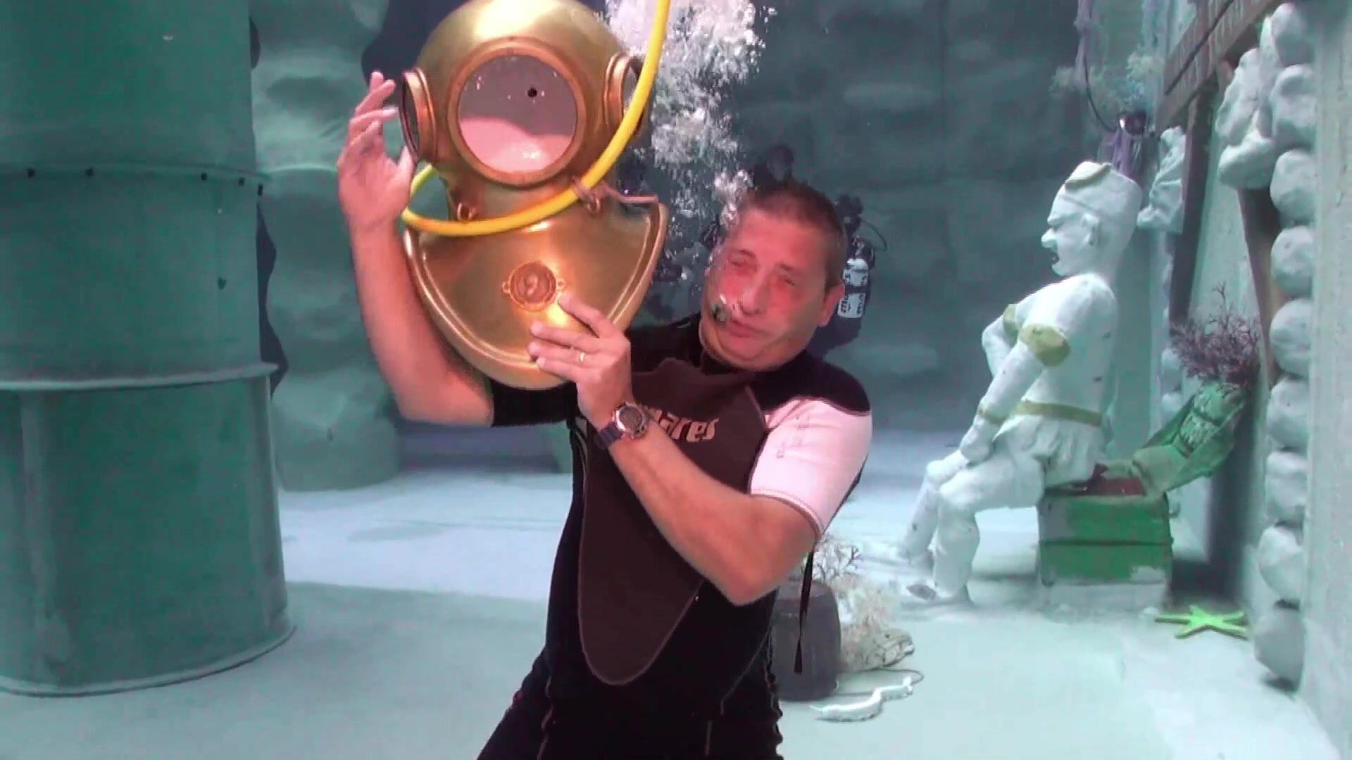 Frank taking his helmet off underwater