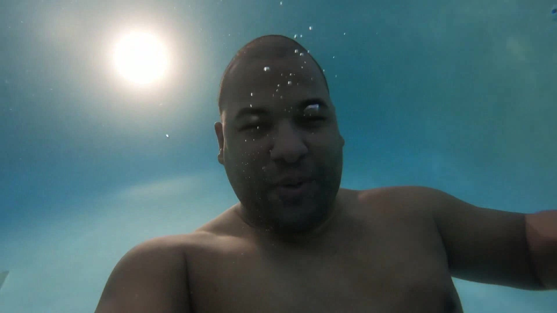 Beefy man swims barefaced underwater