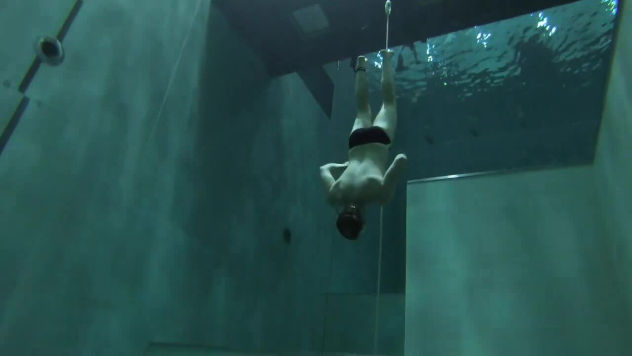 Diving deep underwater in speedos