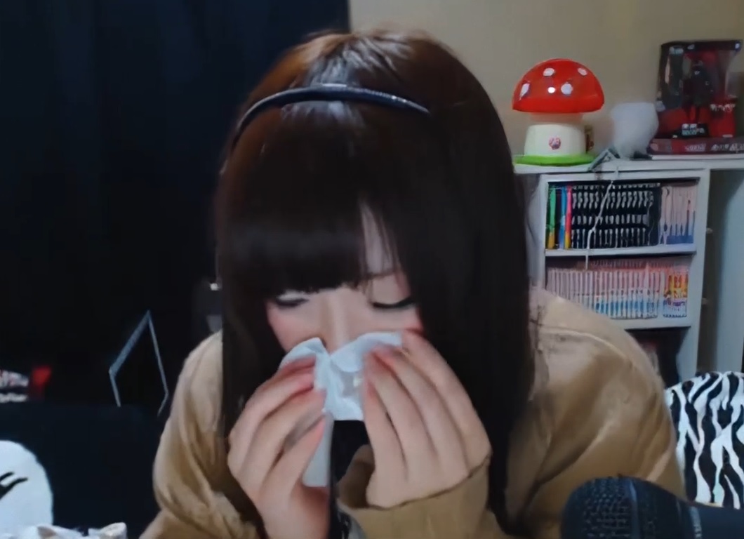 Japanese girl blowing her nose from a bad cold