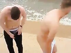 young lad taking his clothes off on the beach