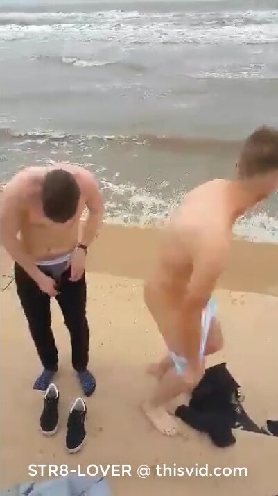 young lad taking his clothes off on the beach