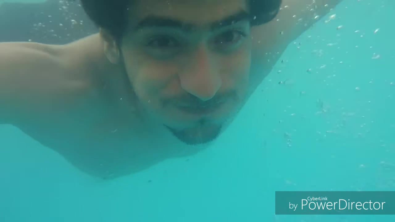 Long haired barefaced guy underwater in pool