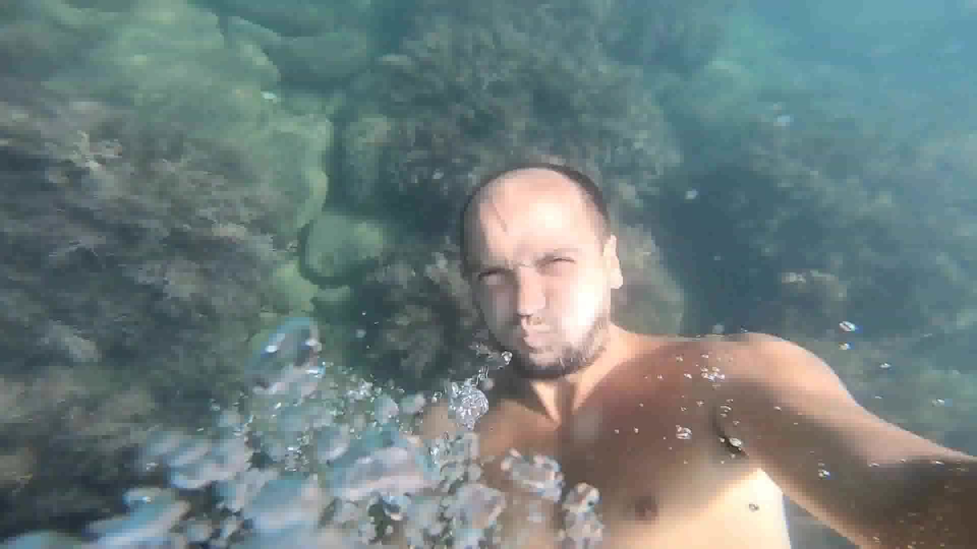 Bearded guy barefaced underwater in sea