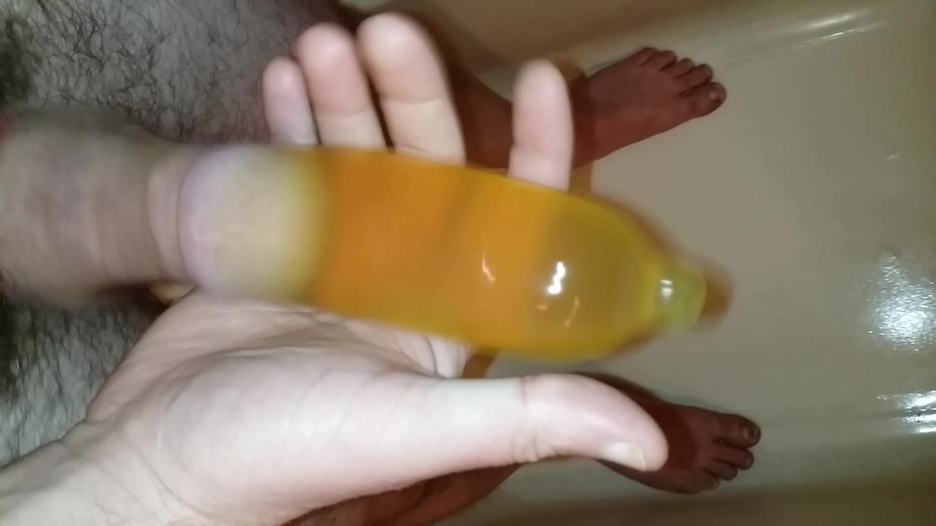 Clip Pissing in a Condom