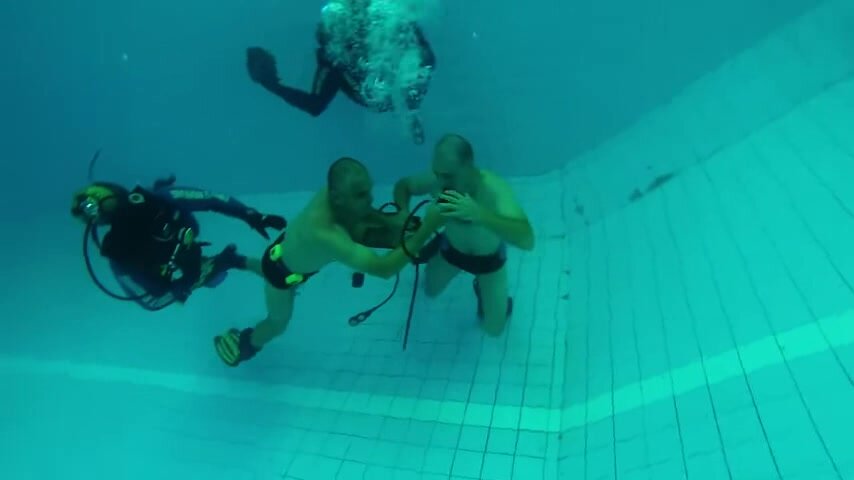Underwater barefaced scubadivers in speedos