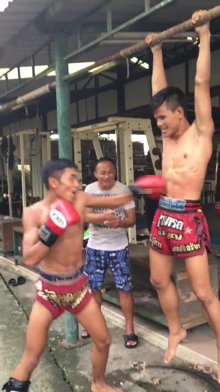 athletic thai boxer getting gutpunched