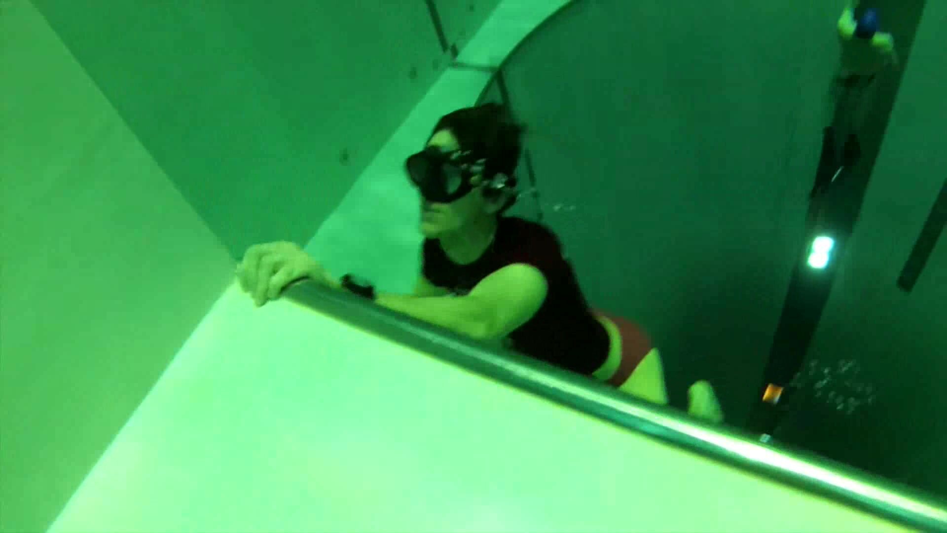 Freedivers in speedos diving deep underwater