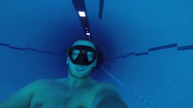 Cute freediver diving deep underwater