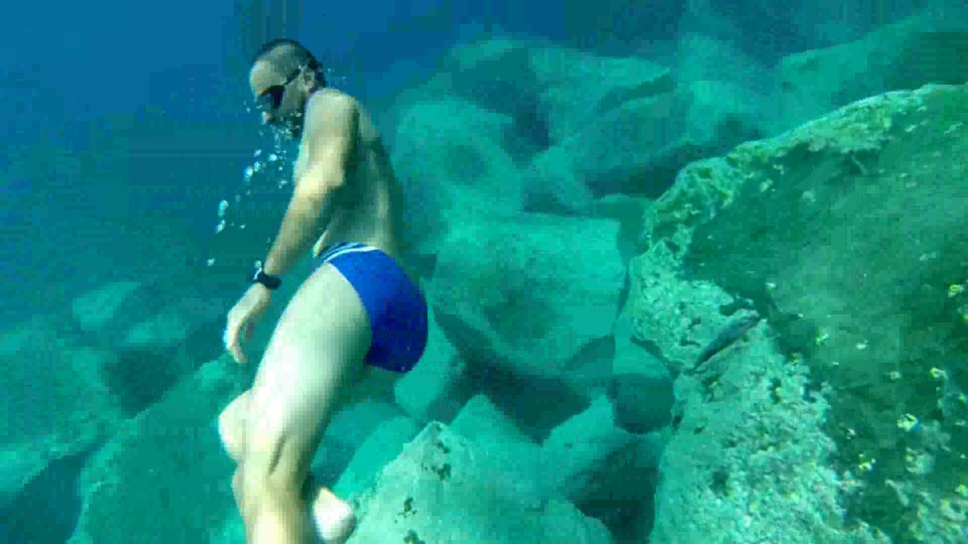 Cute guy underwater in blue speedo