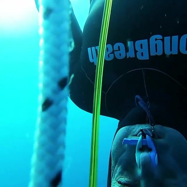 Barefaced freediver underwater in tight wetsuit - video 2
