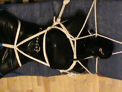 Boot to face - restrained rubberslave in the hogsack