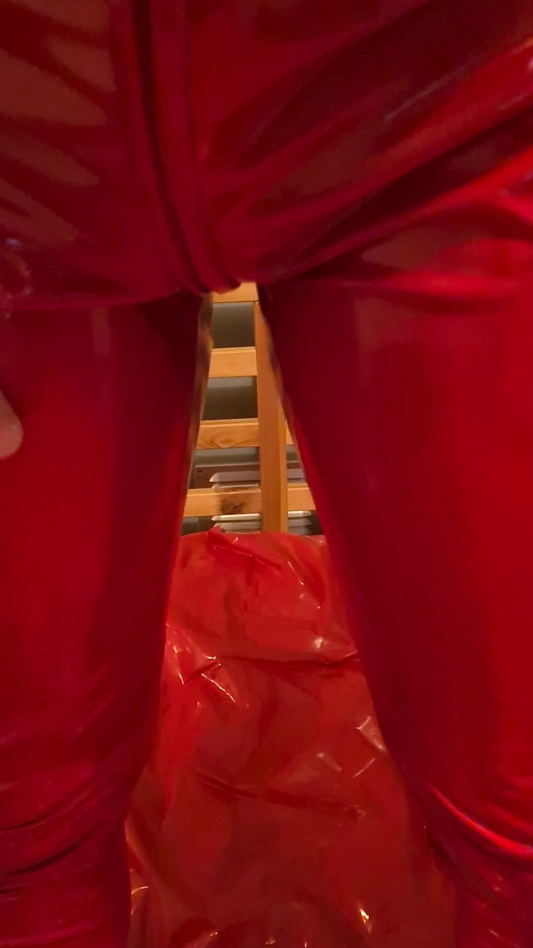 Red PVC catsuit filled with piss on bed