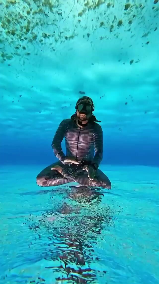 Underwater yoga in tight wetsuit