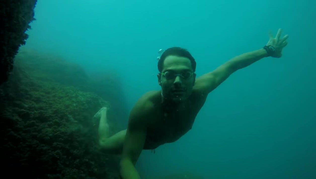 Freediving underwater in speedo and goggles