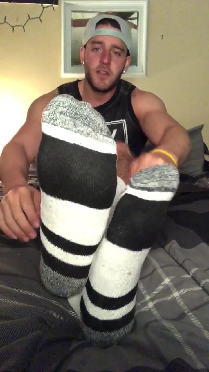 Aggressive verbal muscular tough guy shows off bare feet and socks