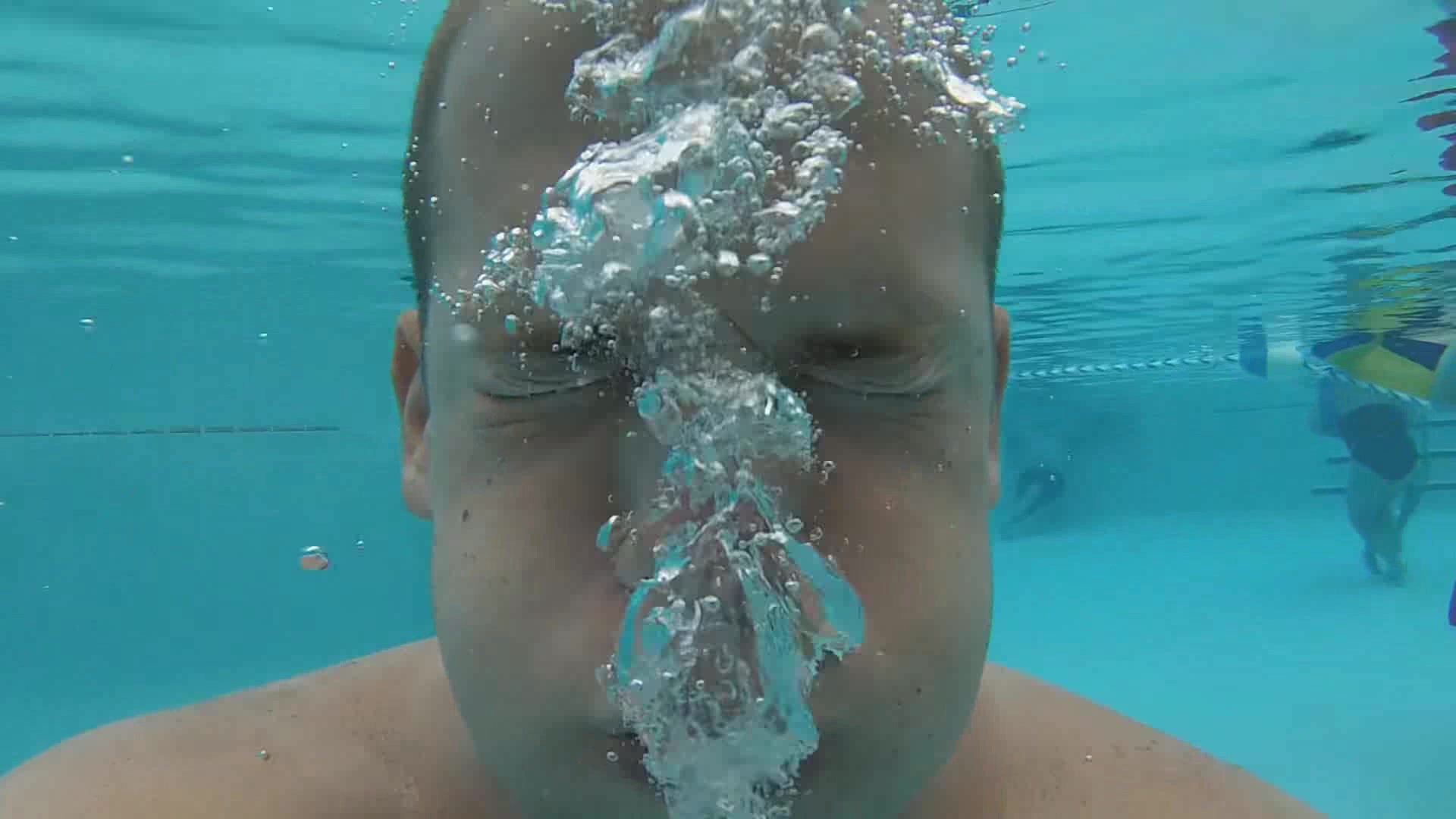 Blowing bubbles barefaced underwater in pool - video 2