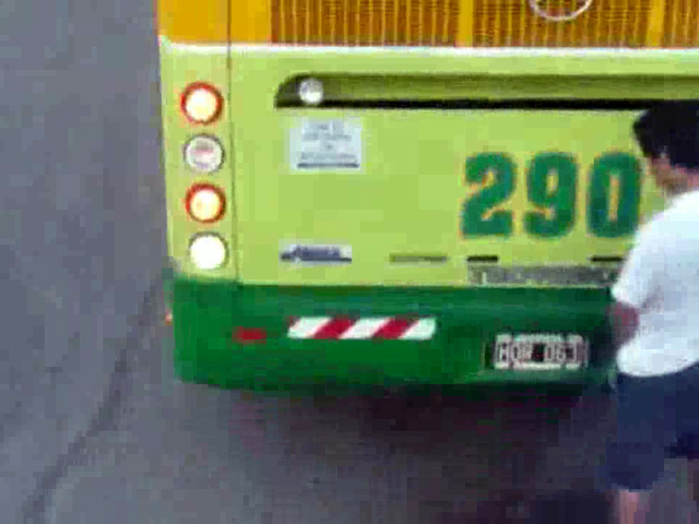 Dude pisses behind a bus