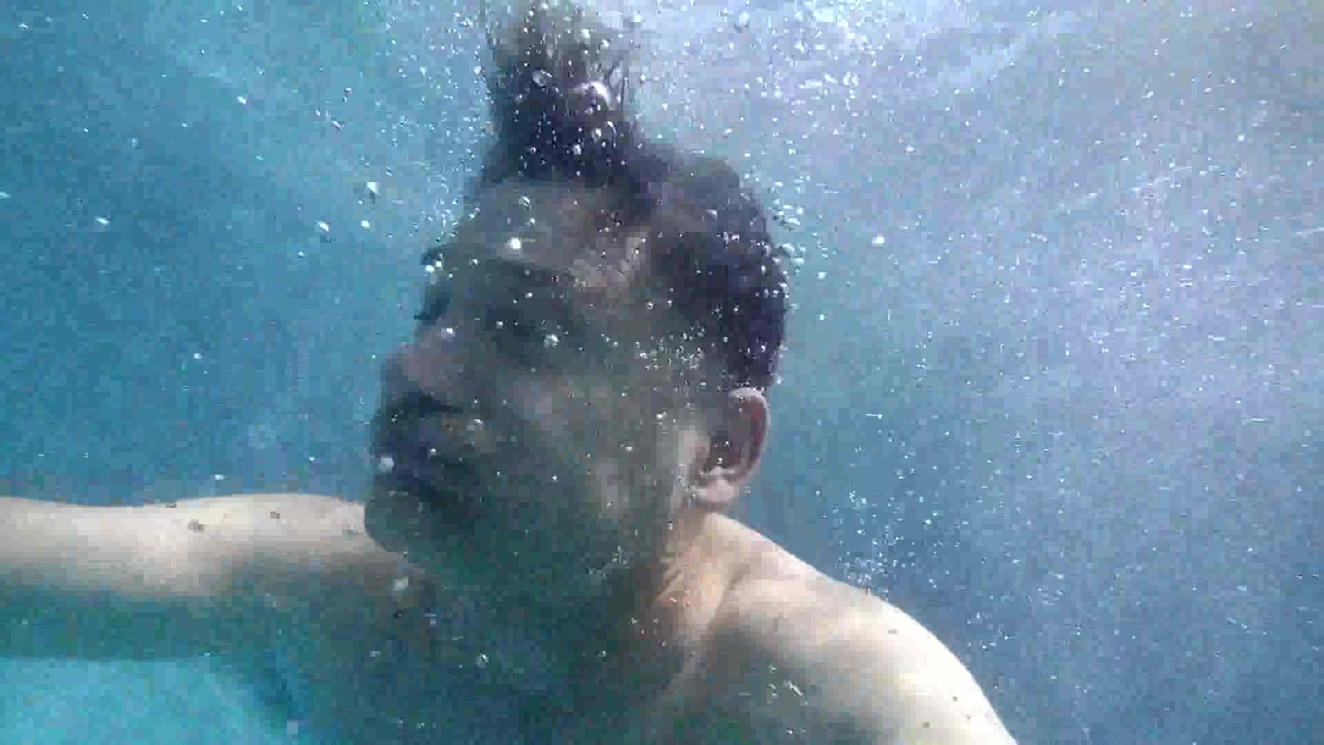 Barefaced mature man underwater