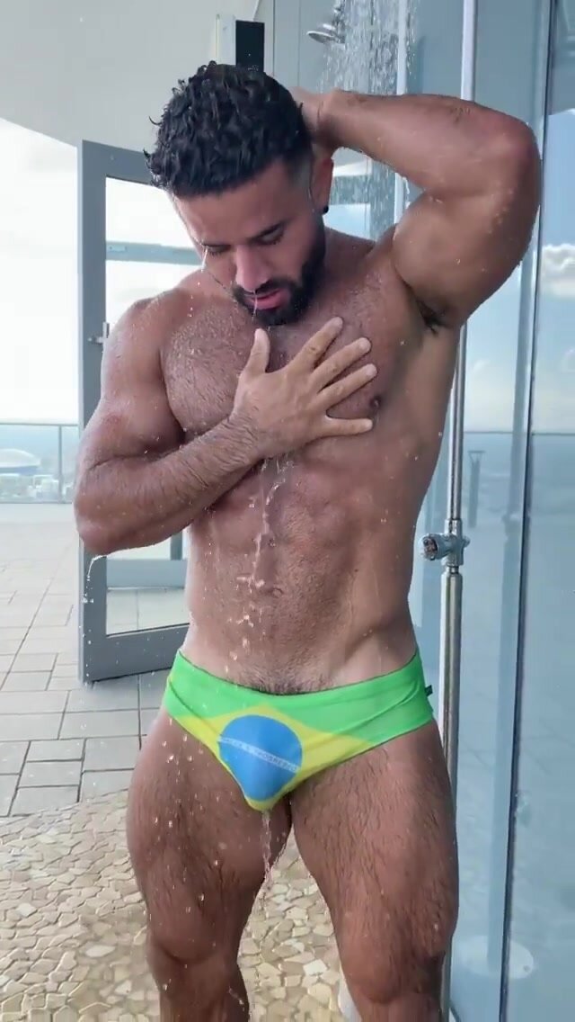 Hairy brazilian hunk showering outside
