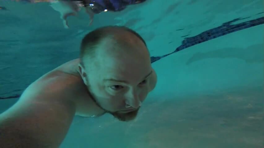 Beefy guy swims barefaced underwater in pool