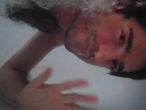 Hairy guy barefaced underwater in tub