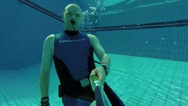 Barefaced hot freediver underwater in wetsuit