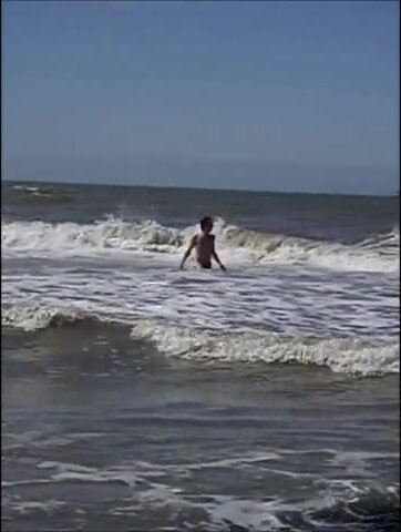 Naked athletic guy coming out of the sea.