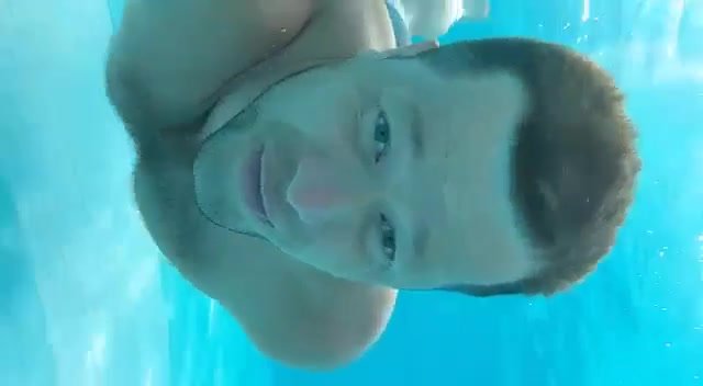 Cute guy swimming barefaced underwater