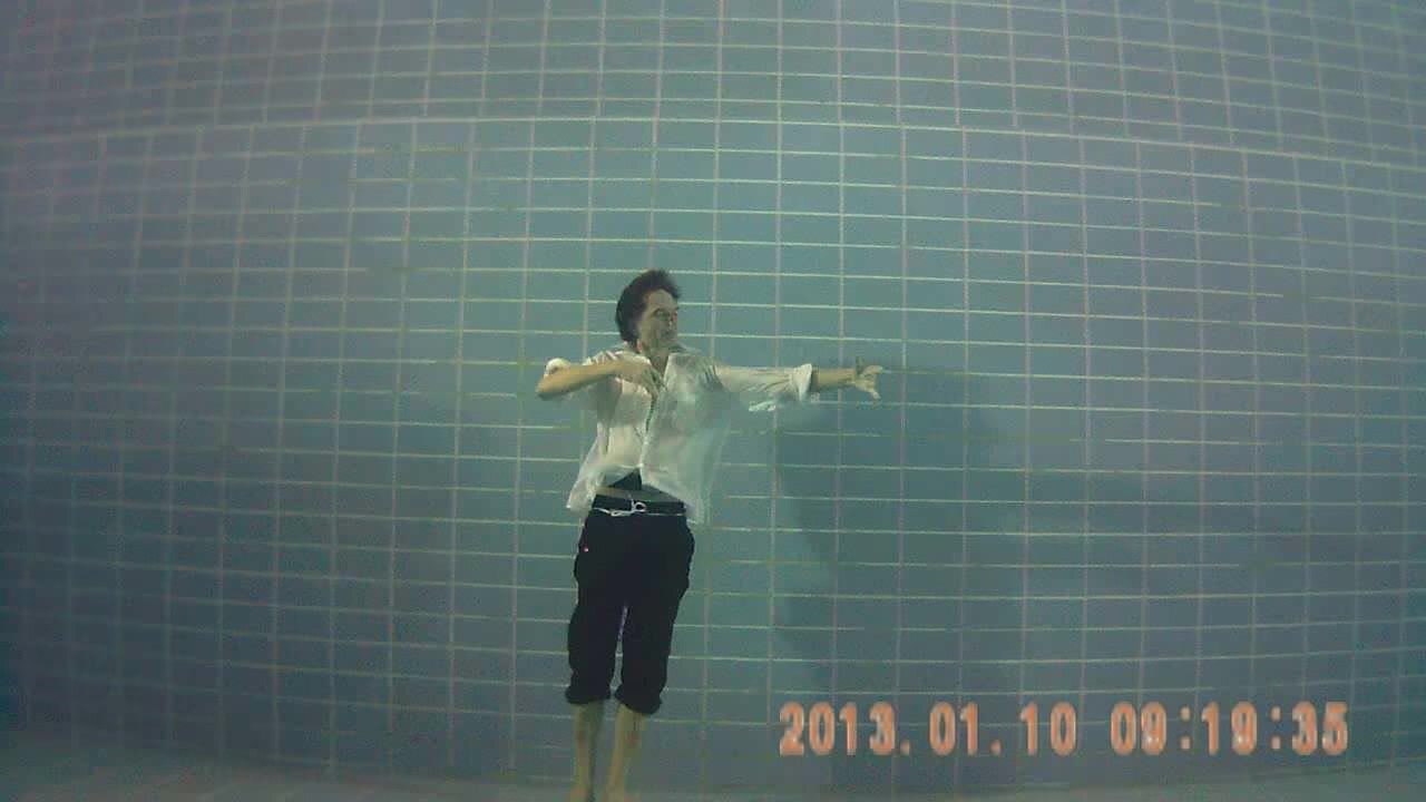 Underwater barefaced clothed dancer in pool