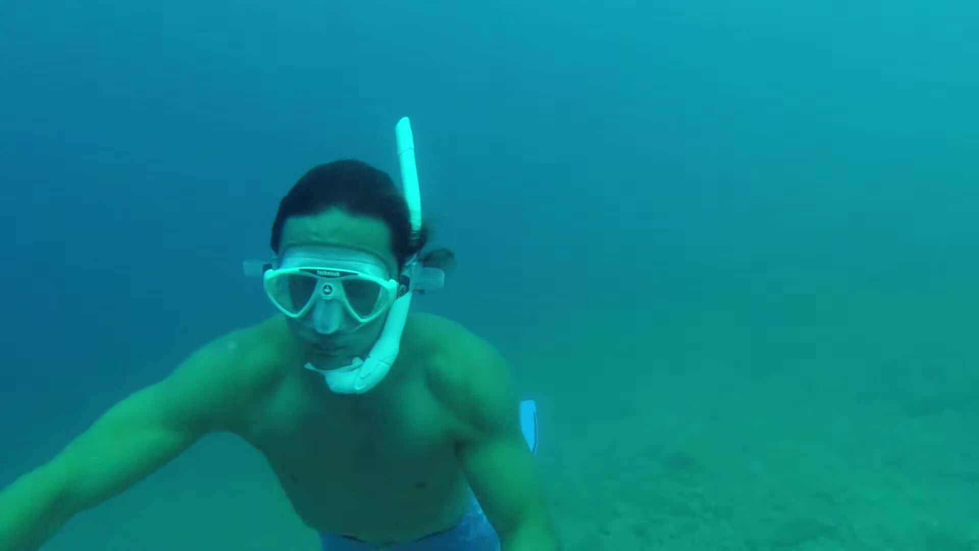 Freediving underwater with white mask