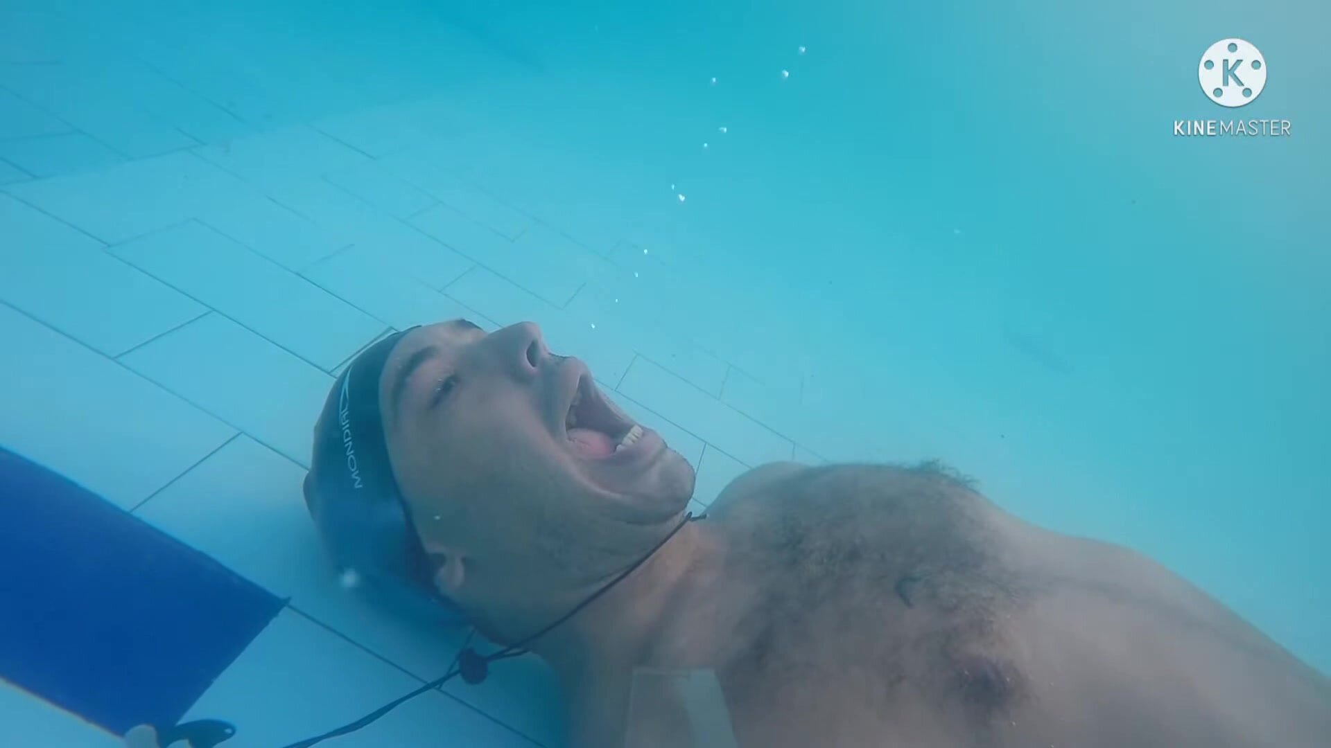Kareem breatholds barefaced and mouth open underwater