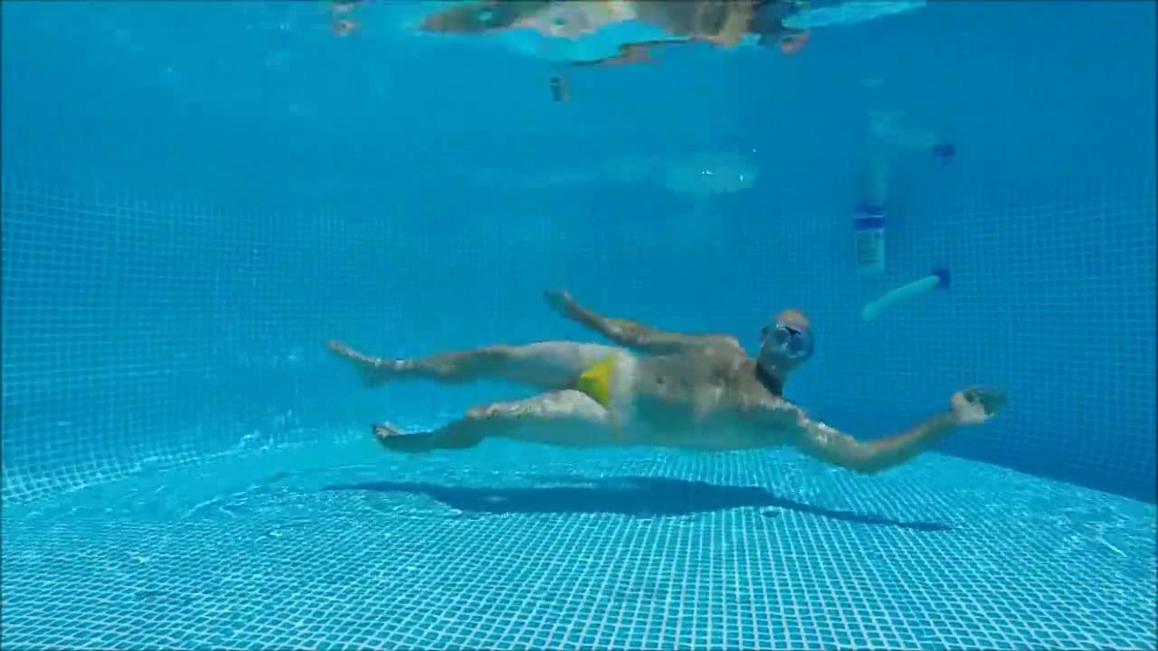 Swimming underwater in yellow speedo