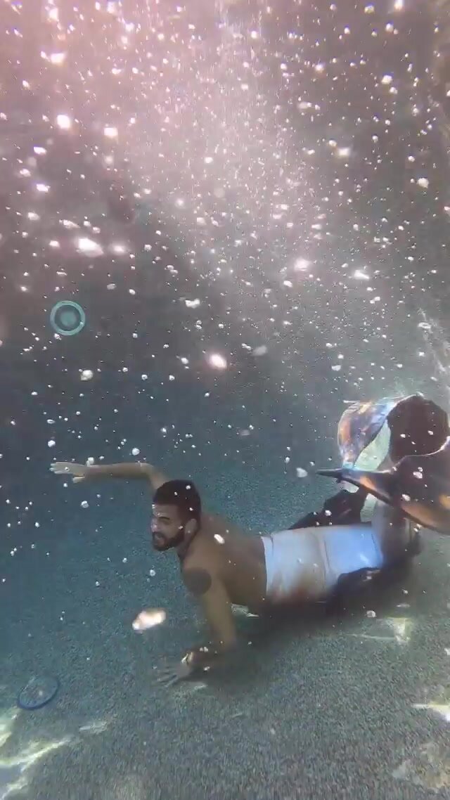 Underwater barefaced bearded merman in pool
