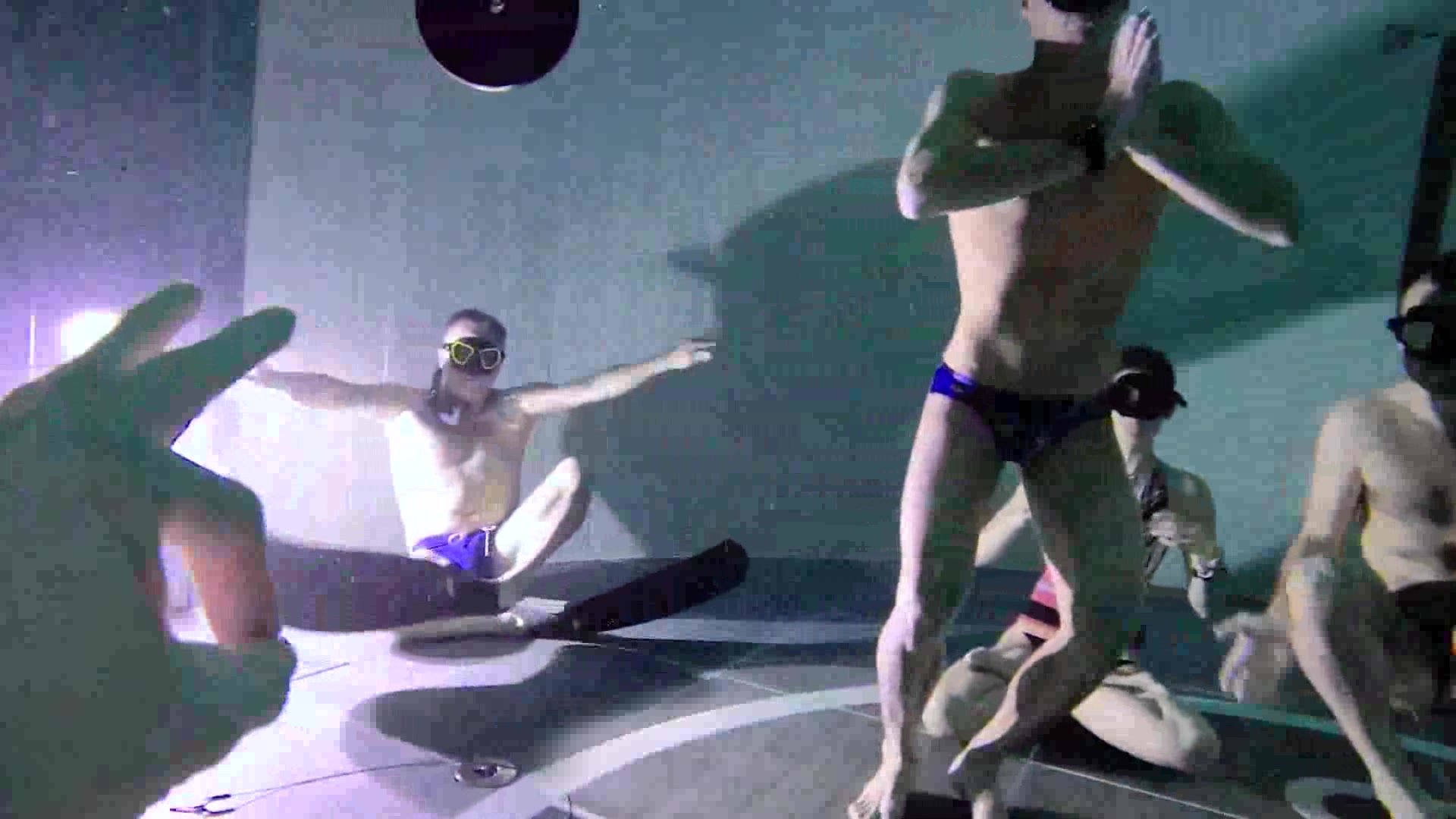 Freedivers deep underwater in bulging speedos