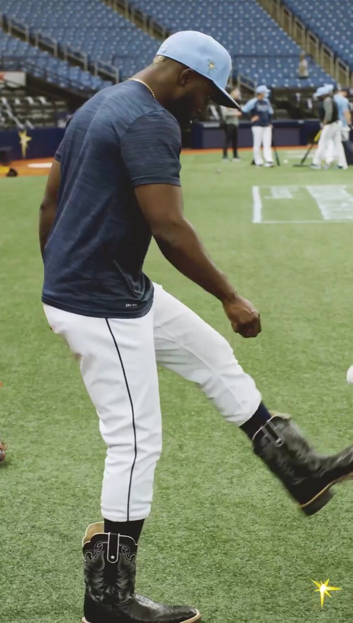 Baseball player in cowboy boots playing with a ball
