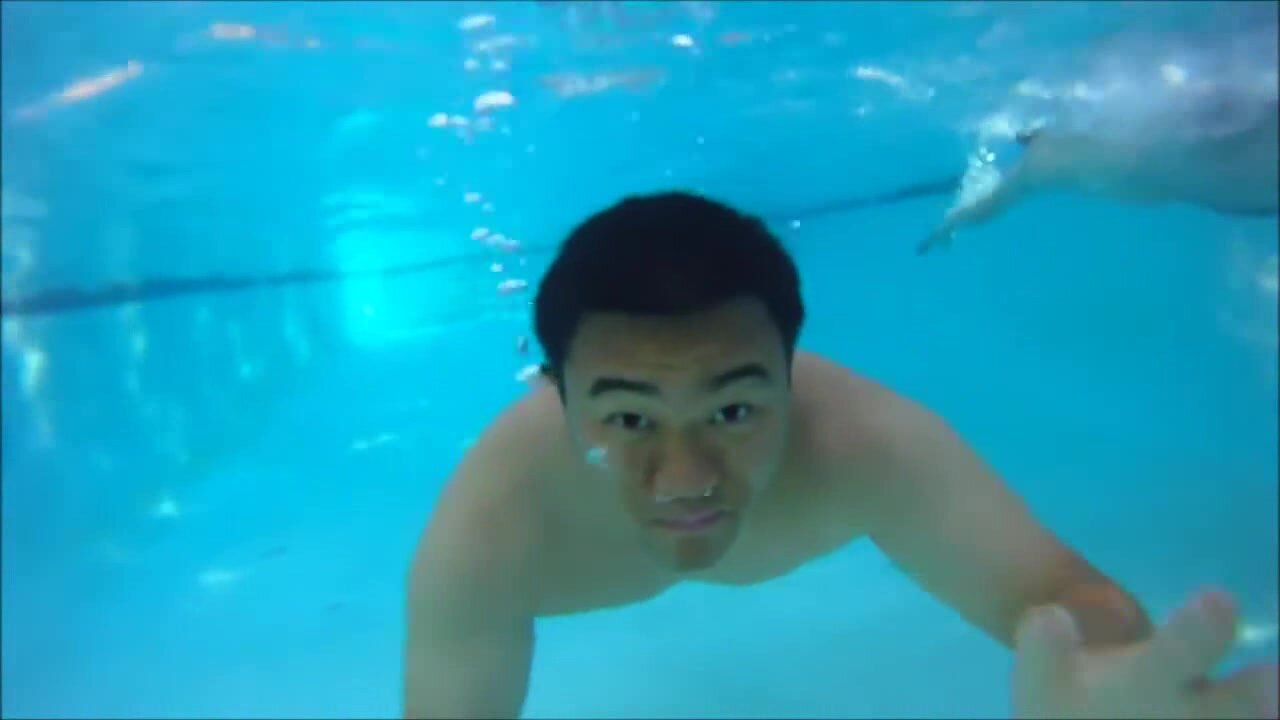 Beefy asian swimming barefaced underwater
