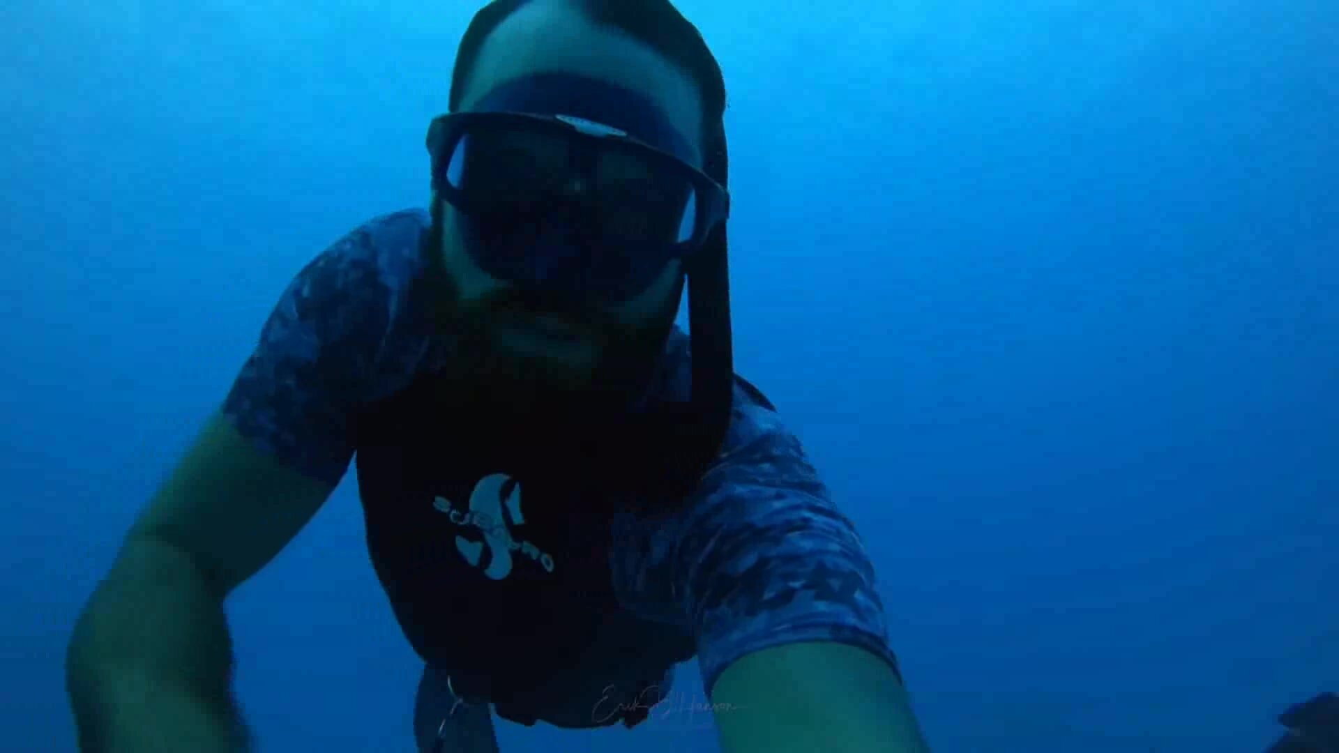 Freediving underwater in wetsuits on a wreck