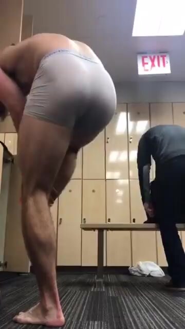 Muscular guy stripping at gym with close-up