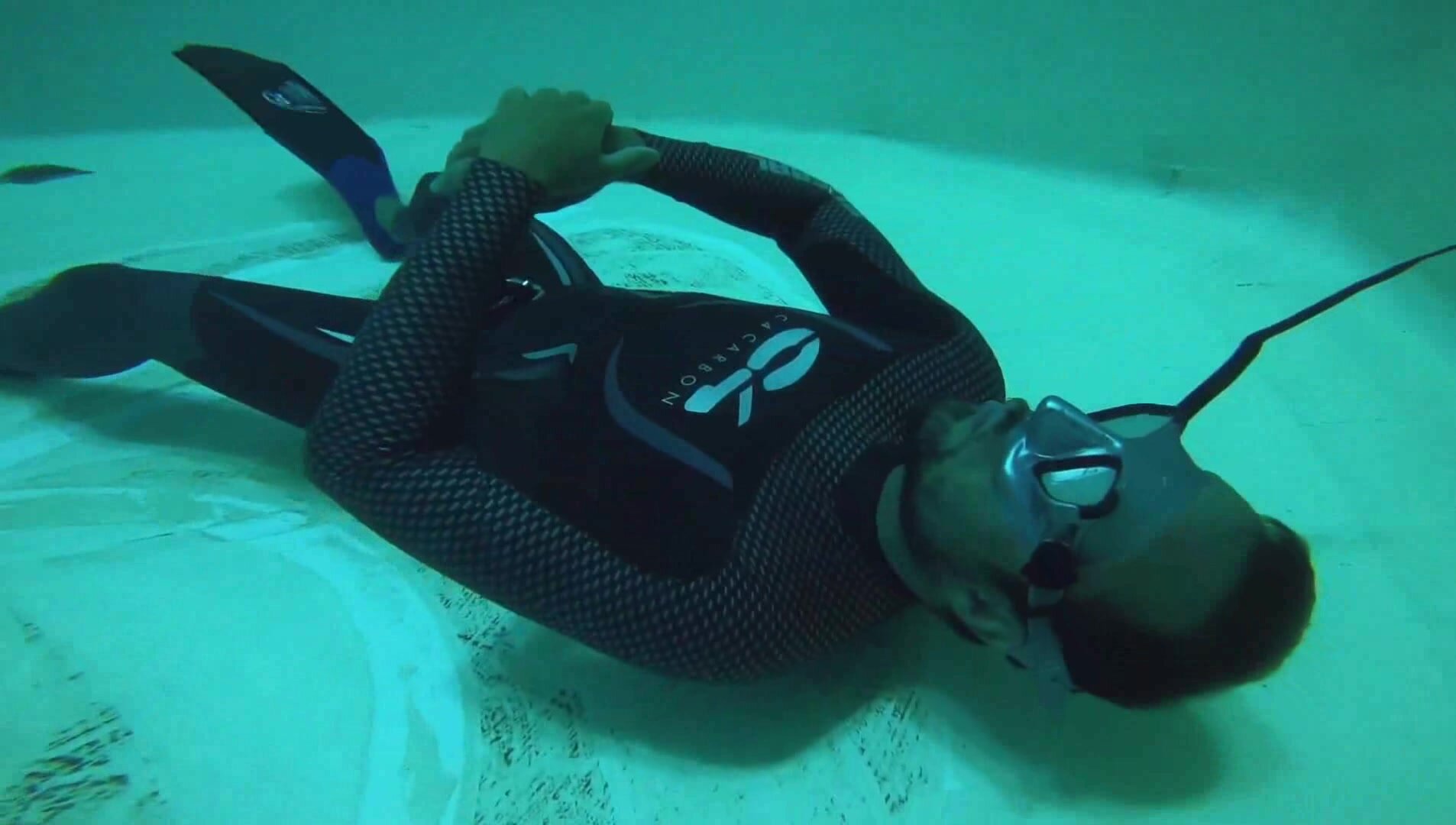 French freediver deep underwater in wetsuit