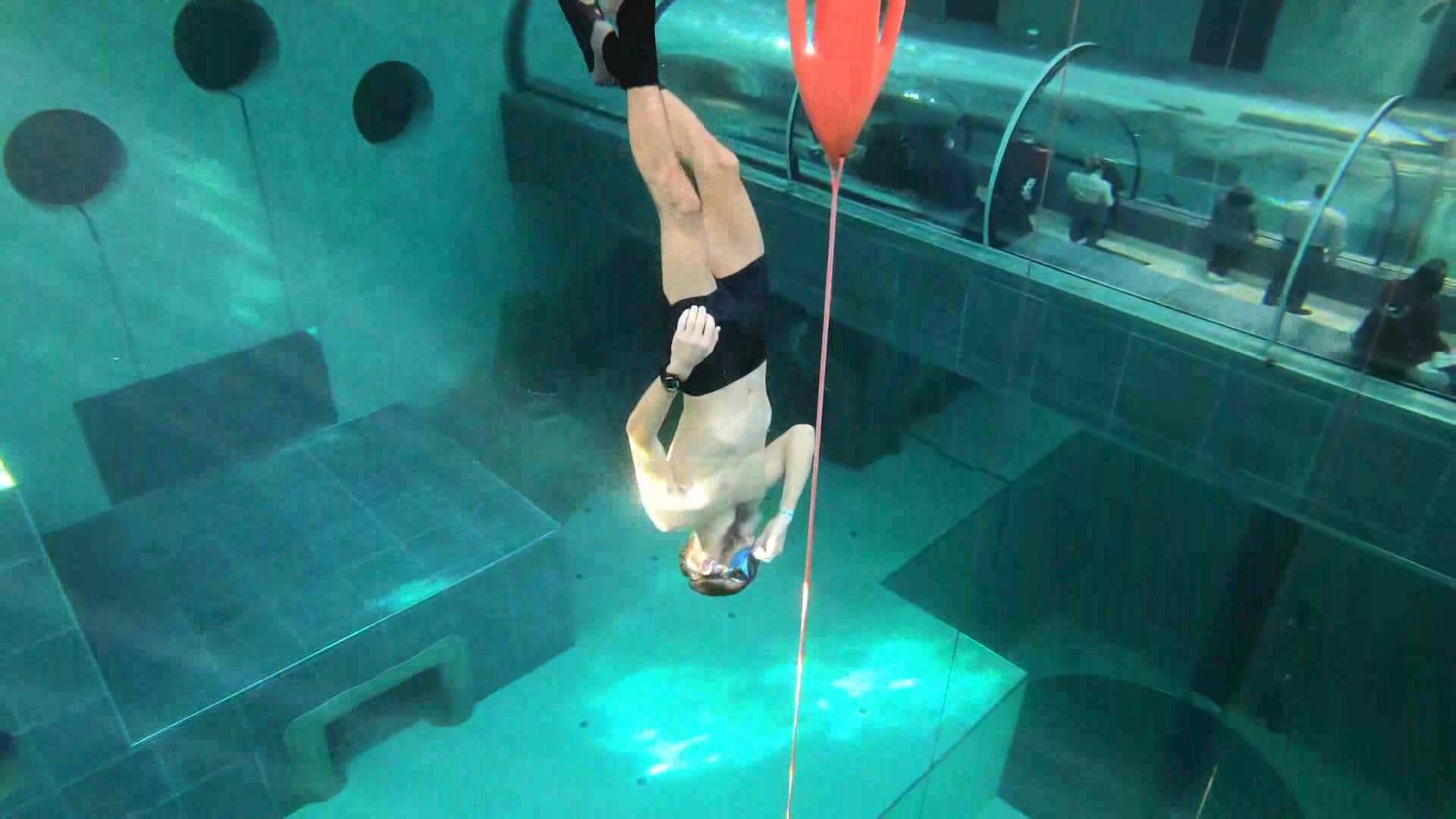 German apneists diving deep underwater in speedos