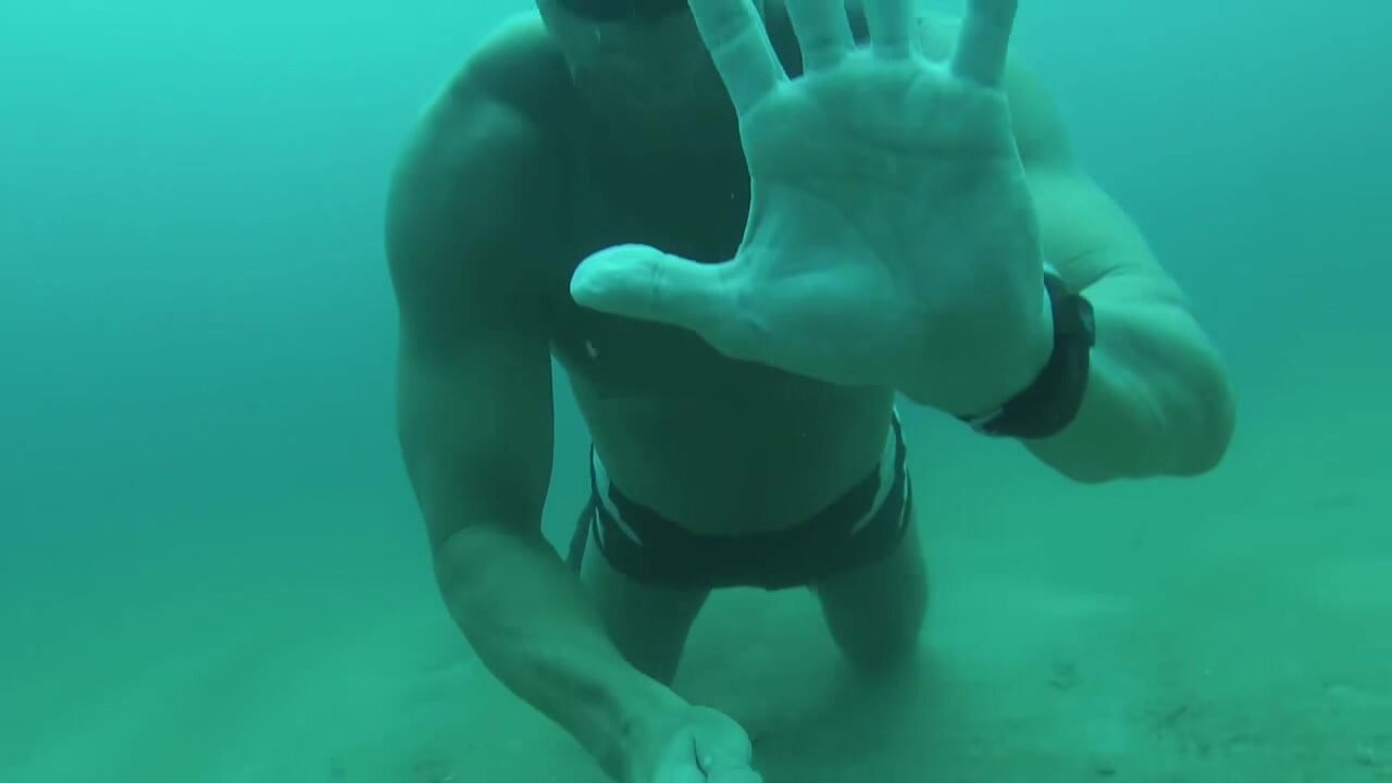 Fit freediver underwater in squarecut speedos