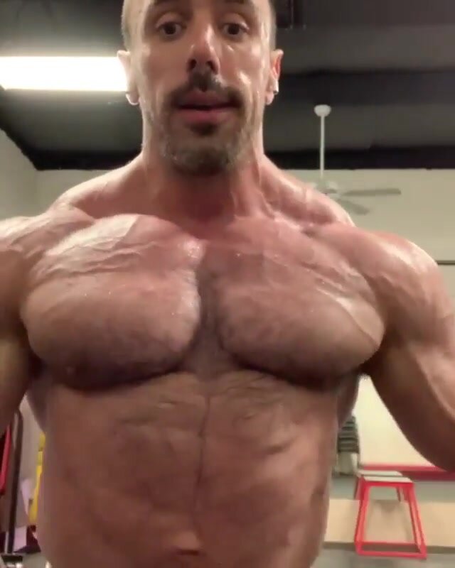 Muscle guy flexing in a gym