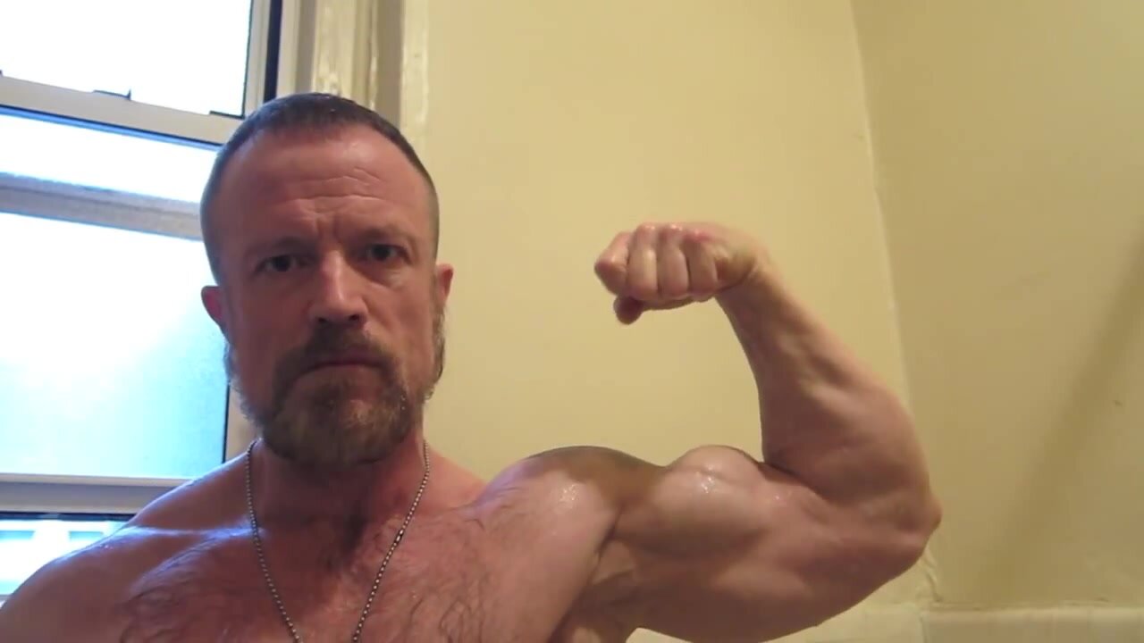 Hairy muscle daddy flexes to show his progress